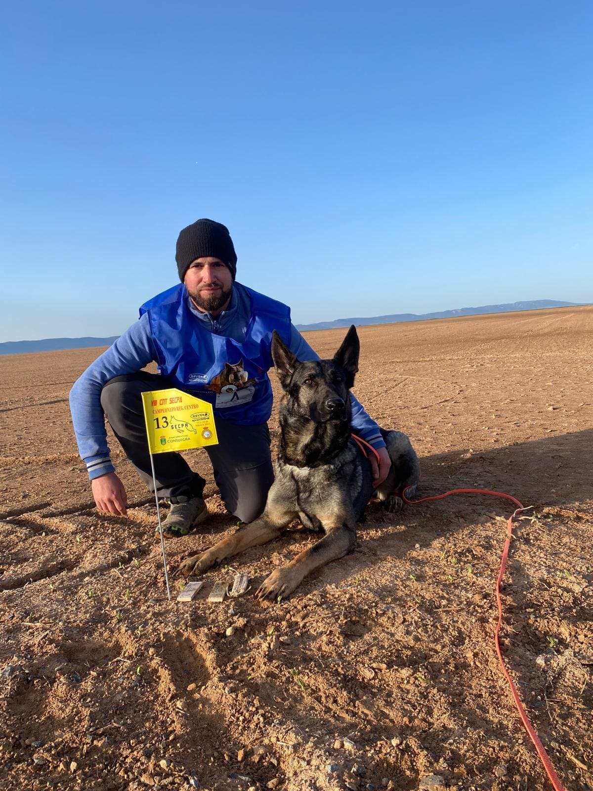 Nando Cañero y Xena junto al banderín número 13 de la prueba de rastro del Campeonato Nacional IGP de la SECPA en Consuegra